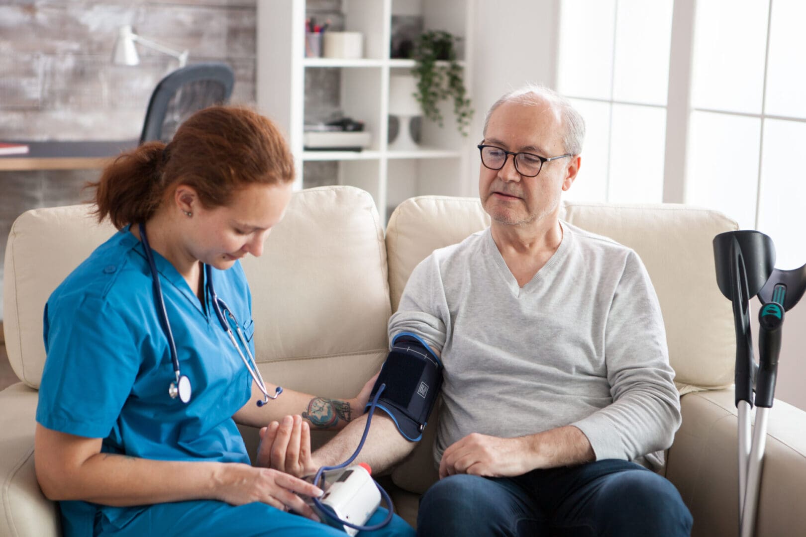 A nurse is checking the blood pressure of an older man.