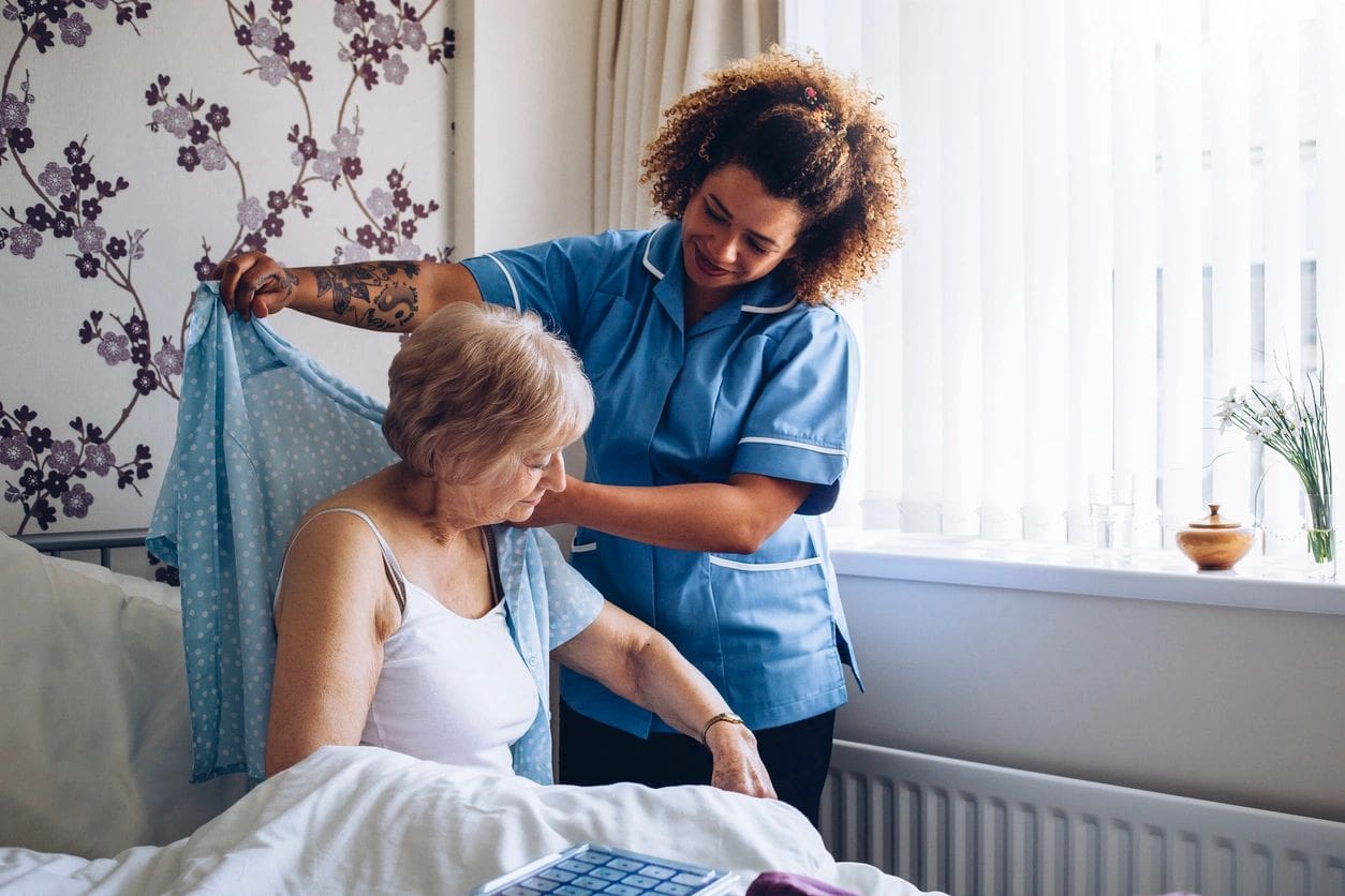 A woman is helping another person in bed